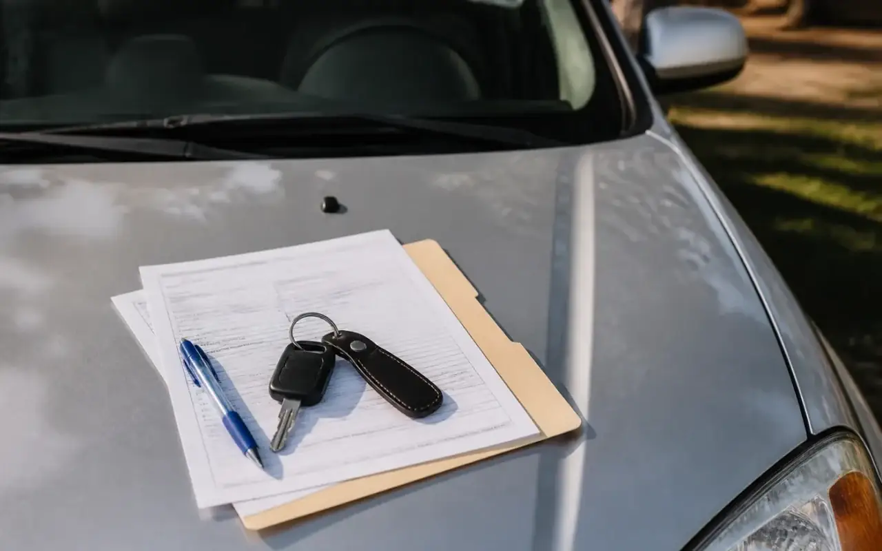 Acte de înmatriculare, chei auto și pix pe capota mașinii — documente necesare la tranzacția unui autoturism second-hand