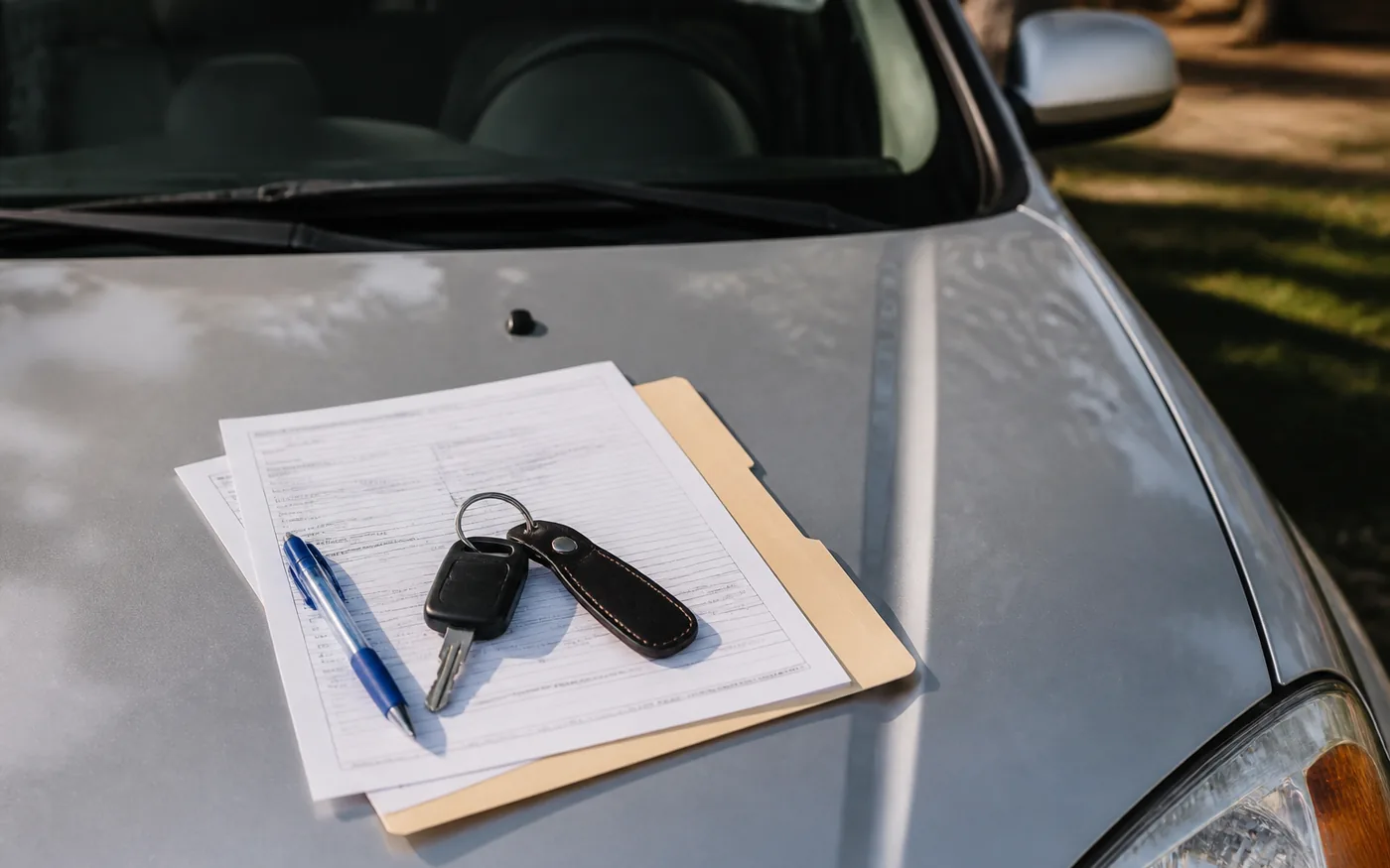 Acte de înmatriculare, chei auto și pix pe capota mașinii — documente necesare la tranzacția unui autoturism second-hand